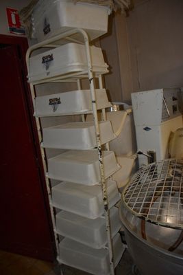 une étagère métallique située à côté des toilettes dans une pièce