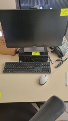 un bureau sur lequel se trouvent un ordinateur, un clavier, une souris et un téléphone