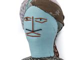 a blue doll with a brown head and a black and white shirt