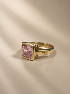 an image of a gold ring with a pink stone on it