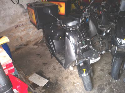 Plusieurs motos sont garées dans un garage où une télévision est accrochée au mur.