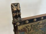 a close up of a wooden chair with a painting on the back