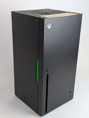a close up of a black xbox game console with a green handle