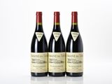 trois bouteilles de vin rouge posées sur une table blanche