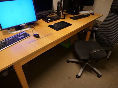 une image représentant un bureau avec deux ordinateurs et une chaise