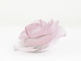 a pink rose that is sitting on a white surface