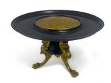 une assiette noire sur laquelle est posée une assiette dorée