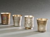trois tasses en argent posées sur une table, l'une à côté de l'autre
