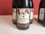 three bottles of wine are lined up on a table