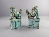pair of ceramic figurines of a lion and a dog on top of a box