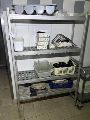 a metal shelf with dishes on it in a kitchen