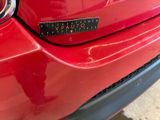 a close up of a red car with a sticker on it