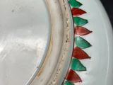 a white vase with a red and green decoration on it
