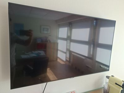 a flat screen tv hanging on a wall in a room