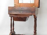 a small wooden desk with a mirror on top of it