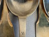 three spoons and two spoons sitting on a table