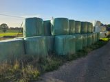 many bales of hay sitting on the side of the road
