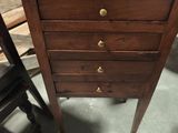 une petite commode en bois dans un coin de la pièce