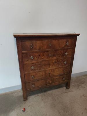 une commode ancienne dans une pièce recouverte de moquette