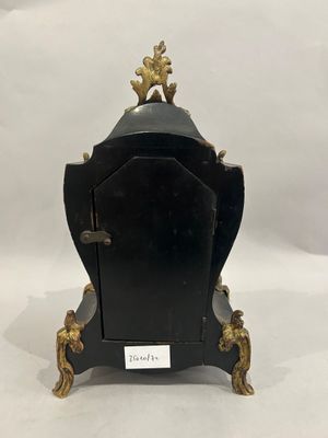 an image of a black and gold clock sitting on top of a table