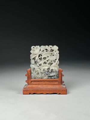 a white jade carving of a lion on a wooden stand