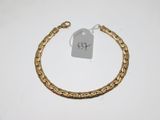 a close up of a gold bracelet with a tag on it