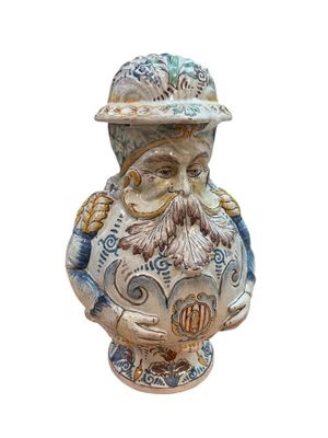 une figurine en céramique représentant un homme portant un chapeau et une barbe