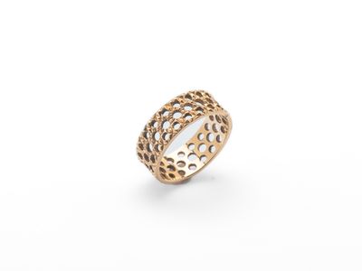une bague plaquée or avec des trous et des perforations au milieu