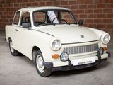 a small white car parked in front of a brick wall