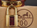 un cadenas en or orné d'une calèche tirée par des chevaux