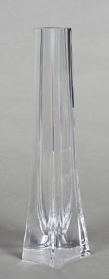 a clear glass vase with a silver base on a table