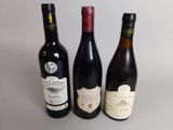 trois bouteilles de vin posées sur une table, l'une à côté de l'autre