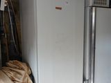 two refrigerators that are in a garage next to each other