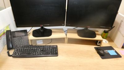 deux écrans d'ordinateur et un clavier sur un bureau