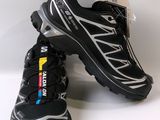 two pairs of black and silver running shoes on a white surface