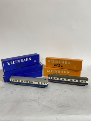 trois wagons de train miniature placés les uns à côté des autres sur une surface blanche
