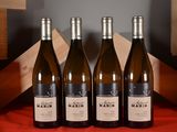 three bottles of wine are lined up on a table