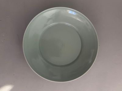 a green bowl sitting on a table with a white background