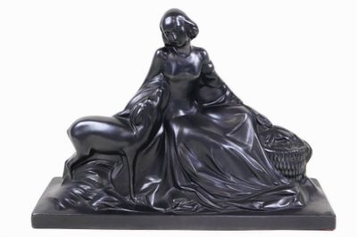 statue d'une femme assise sur un rocher avec un chien