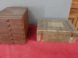 deux vieux coffres en bois posés sur une nappe rouge