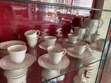 de nombreuses tasses et soucoupes exposées dans une vitrine