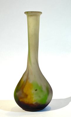 un vase vert et jaune posé sur une surface blanche