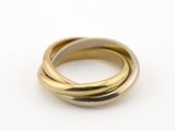 gros plan d'une bague en or et en argent sur une surface blanche