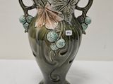 un vase vert avec des fleurs posé sur une table