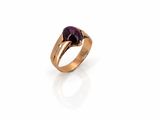 a close up of a gold ring with a purple stone