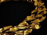 an image of a gold necklace on a black background