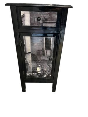 une petite armoire noire surmontée d'un miroir