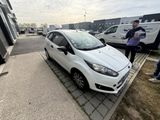 a small white car parked on the side of the road
