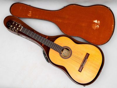 une photo d'une guitare dans son étui, posée sur une table