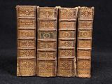 several old books are stacked on top of each other on a black surface